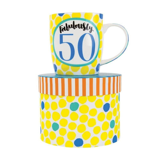 image of a predominantly yellow coloured mug, white background with lots of yellow circles and a large green outlined circle in the centre with text saying Fabulously 50 in it. the mug is sat on top of a hat style gift box.