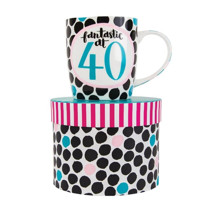 image of a predominantly black and white coloured mug, white background with lots of black circles and a large pink outlined circle in the centre with text saying Fantastic at 40 in it. the mug is sat on top of a hat style gift box.