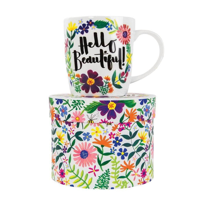image of a mug, white background with lots of brightly coloured flowers and a large green outlined space in the centre with text saying hellow beautiful! in it. the mug is sat on top of a hat style gift box.