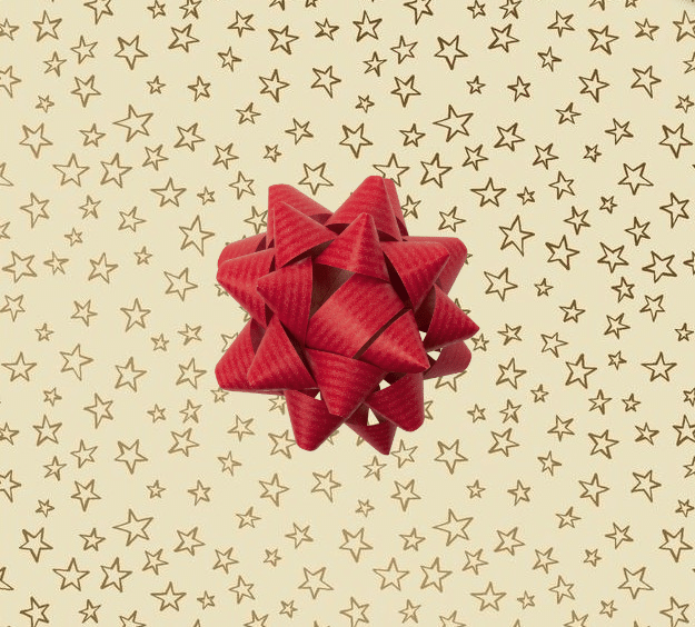 image of a square of wrapping paper, the paper is cream in colour with lots of gold stars, in the corner of the gift wrap paper is a gold gift wrapping bow