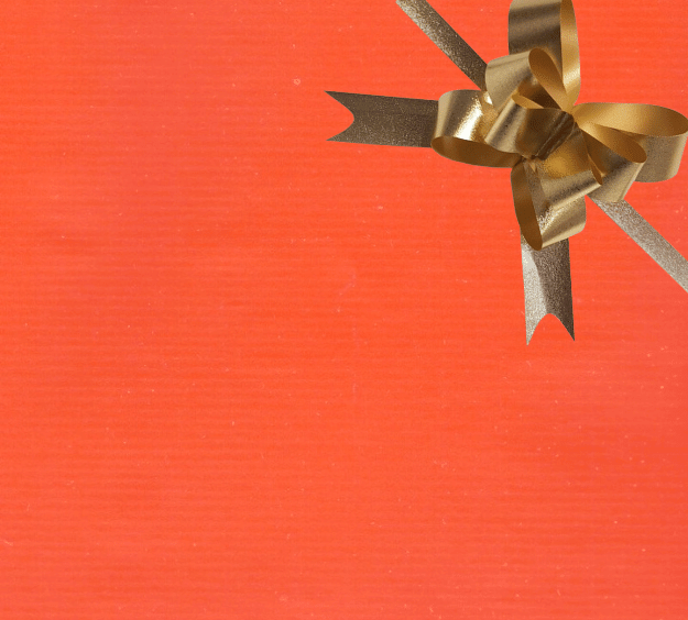 image of a square of wrapping paper, the paper is a solid orange kraft paper, in the corner of the gift wrap paper is a white gift wrapping bow