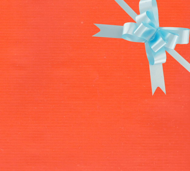 image of a square of wrapping paper, the paper is a solid orange kraft paper, in the corner of the gift wrap paper is a lilac gift wrapping bow