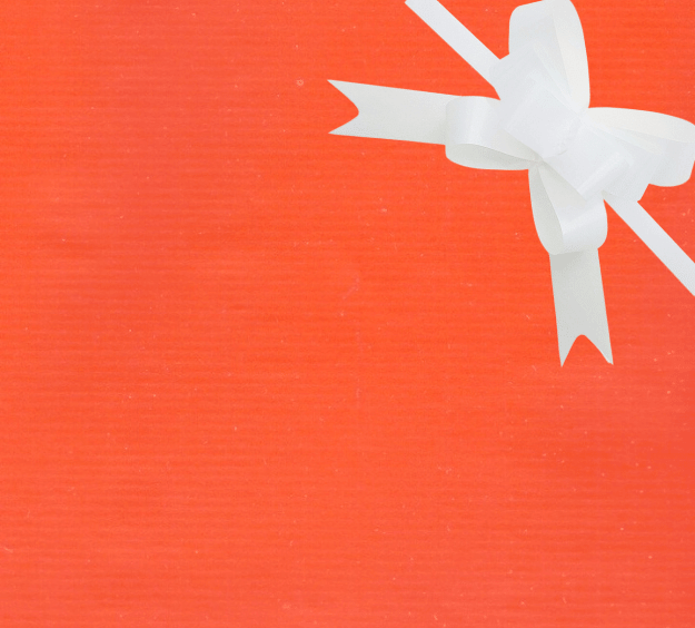image of a square of wrapping paper, the paper is a solid orange kraft paper, in the corner of the gift wrap paper is a light blue gift wrapping bow