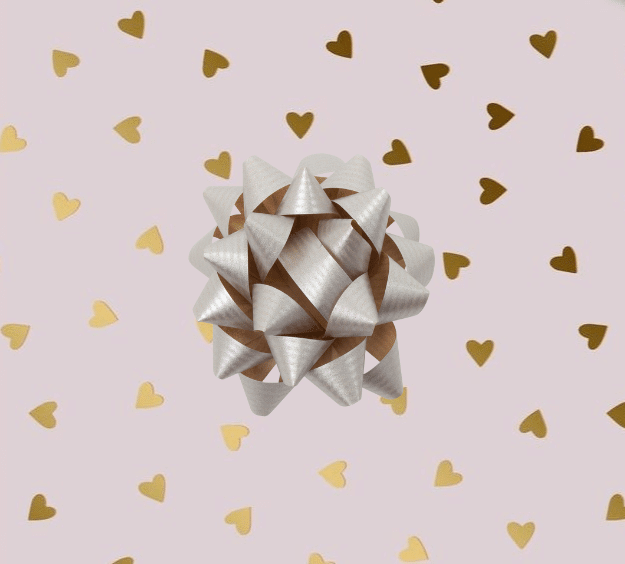 image of a square of wrapping paper, the paper has a pink background and features lots of little gold hearts all over it