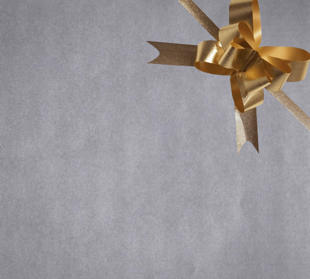 image of a square of wrapping paper, the paper is a solid silver kraft paper, in the corner of the gift wrap paper is a green gift wrapping bow