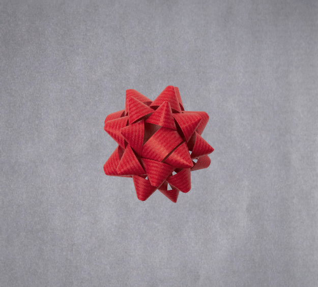 image of a square of wrapping paper, the paper is a solid silver kraft paper, in the centre of the gift wrap paper is a red paper gift wrapping bow