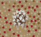 image of a square of wrapping paper, the paper has a gold background and features lots of red, gold and cream stars 