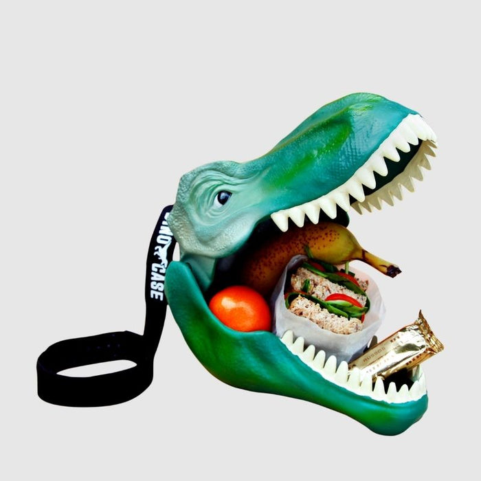 A green dinosaur head with wide open mouth, bright white teeth and the mouth is filled with sandwiches, fruit and a chocolate bar. At the back of the dinosaur head is a black carry strap to make carrying this dinosaur lunch box easy.