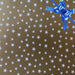 image of a square of wrapping paper, the paper is gold and features lots of solid white stars