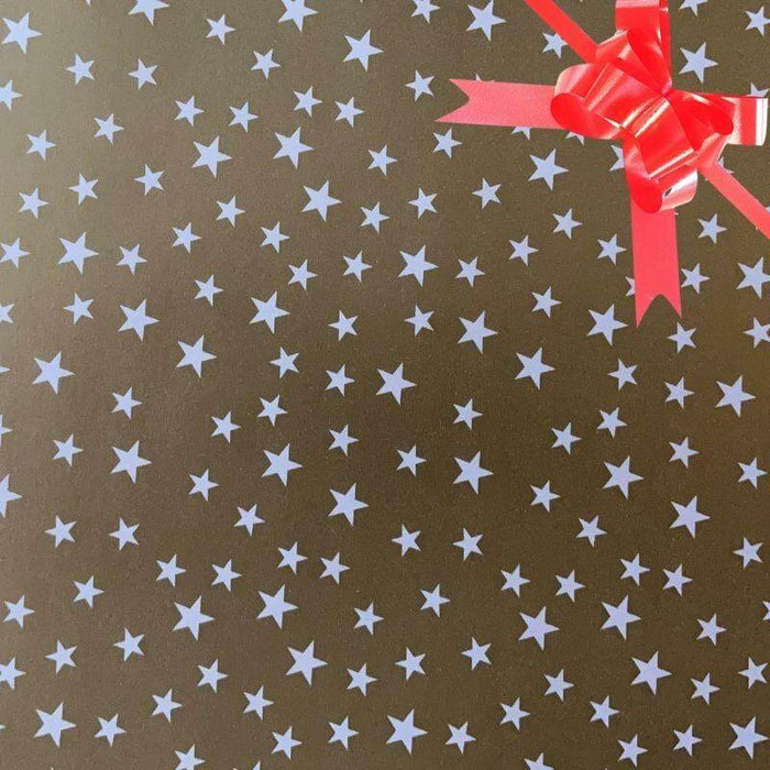 image of a square of wrapping paper, the paper is gold and features lots of solid white stars, in the centre of the gift wrap paper is a green paper gift wrapping bow