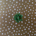 image of a square of wrapping paper, the paper is gold and features lots of solid white stars, in the corner of the gift wrap paper is a white gift wrapping bow
