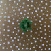 image of a square of wrapping paper, the paper is gold and features lots of solid white stars, in the corner of the gift wrap paper is a white gift wrapping bow