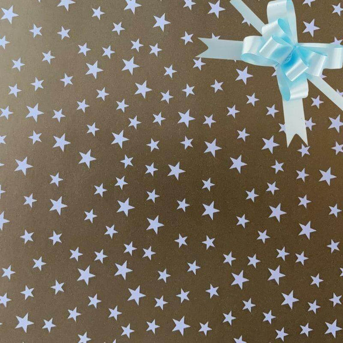 image of a square of wrapping paper, the paper is gold and features lots of solid white stars, in the corner of the gift wrap paper is a green gift wrapping bow