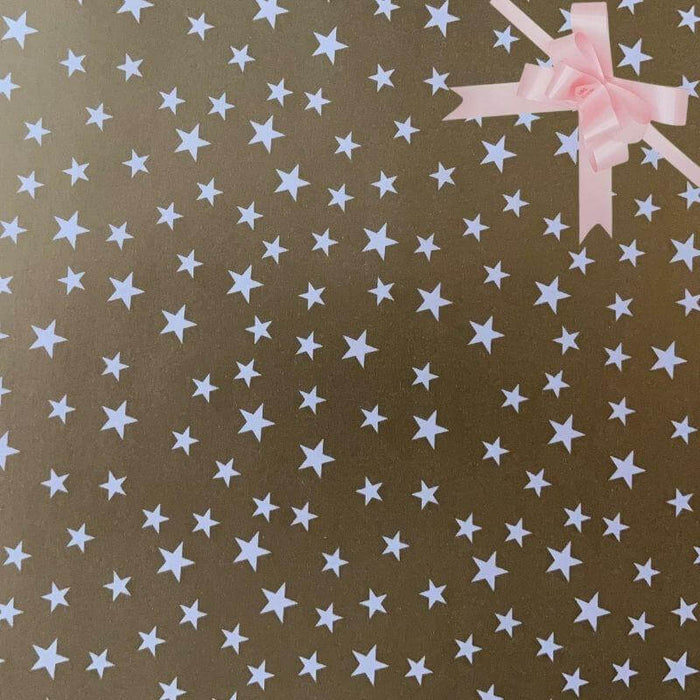 image of a square of wrapping paper, the paper is gold and features lots of solid white stars, in the corner of the gift wrap paper is a gold gift wrapping bow