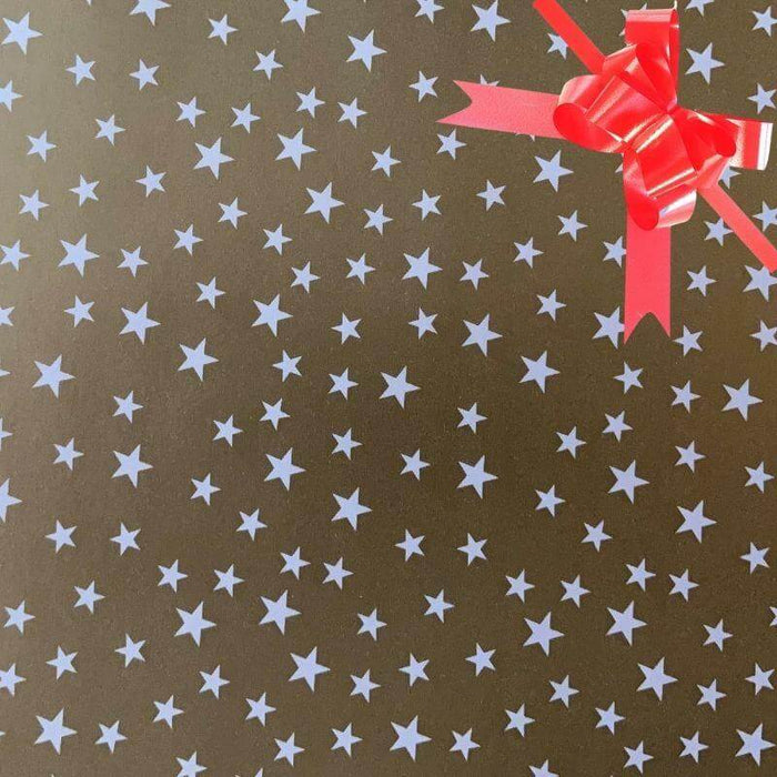 image of a square of wrapping paper, the paper is gold and features lots of solid white stars, in the corner of the gift wrap paper is a silver gift wrapping bow