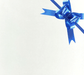 image of a square of wrapping paper, the paper is a solid white kraft paper, in the corner of the gift wrap paper is a bright blue gift wrapping bow