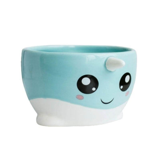 image of a mug with the face and features of a cute narwahl. light blue and white in colour with big eyes and a white horn.